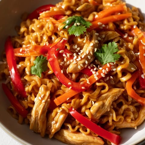 Tender chicken and crisp vegetables coated in a glossy, spicy sauce mingle with chewy noodles in this vibrant Spicy Ramen Stir-Fry.
