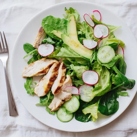 Freshly prepared Spring Detox Chicken Salad featuring tender grilled chicken breast, avocado, and crunchy vegetables, drizzled with homemade lemon dressing for a light and healthy meal.