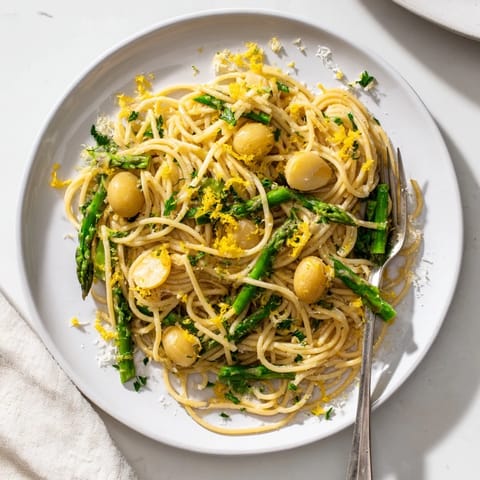 Plated Roasted Garlic & Asparagus Pasta with golden roasted garlic cloves and bright green asparagus over spaghetti.