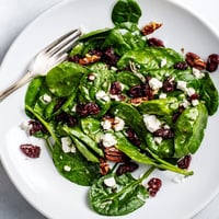 Fresh spinach leaves topped with crumbled goat cheese, candied pecans, and dried cranberries tossed in tangy balsamic vinaigrette.  
